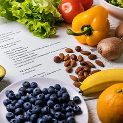 Fruits, vegetables, and nuts scattered around a recipe