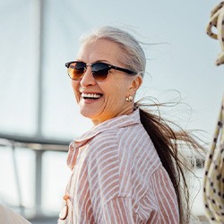 Woman smiling while enjoying the breeze from a sailboat 