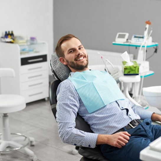 A smiling young man sitting in a dentist’s chair