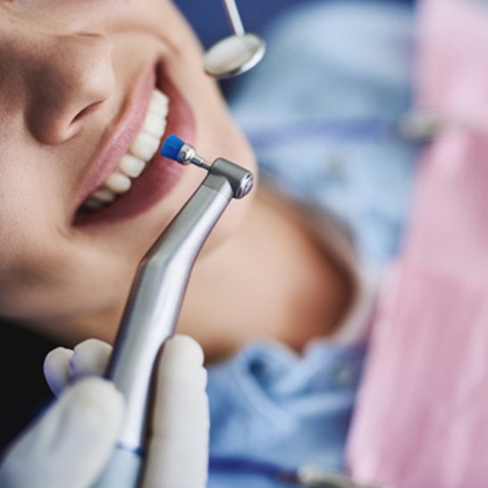 A young woman receiving a teeth cleaning and polishing