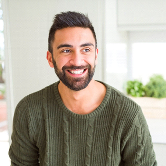 person sitting in a kitchen and smiling