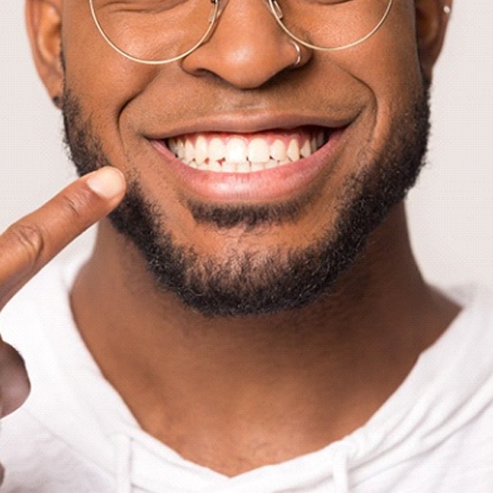 close-up of a man pointing to his smile