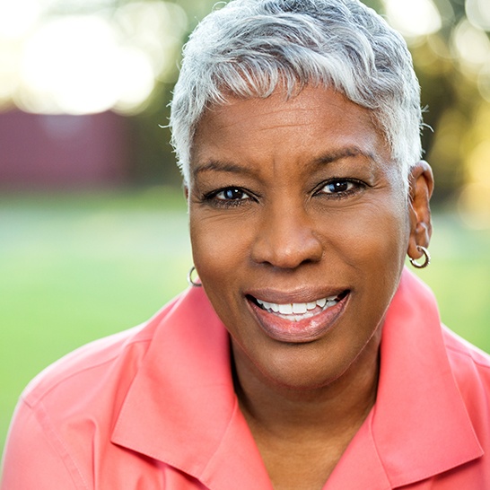 Woman with gorgeous smile after dental implant tooth replacement