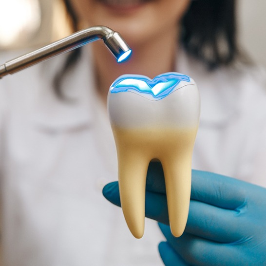 Dentist using fake tooth to demonstrate tooth-colored fillings in Mission Viejo, CA
