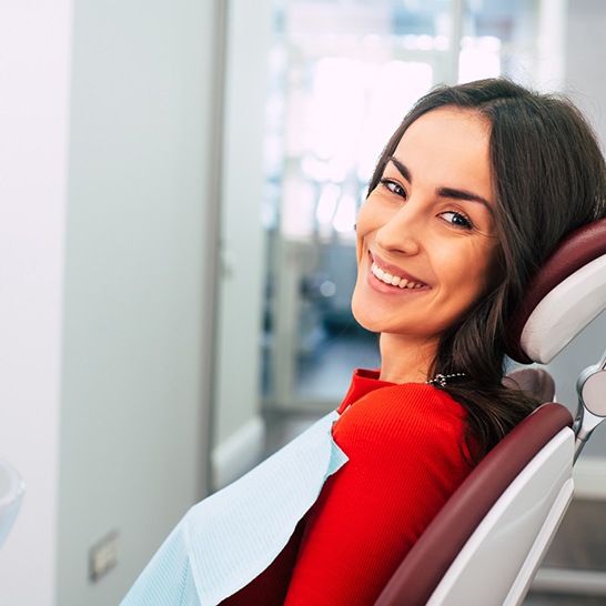 Female dental patient in red shirt sitting and smiling