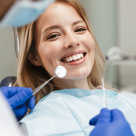 Smiling young woman in dental chair about to undergo exam