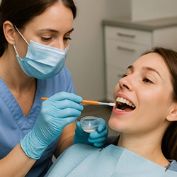 Dentist applying fluoride to woman’s teeths