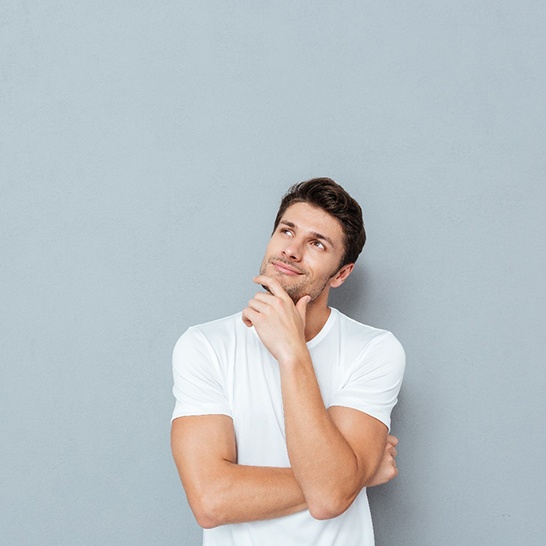 Man in white shirt thinking, wondering if ne needs gum contouring