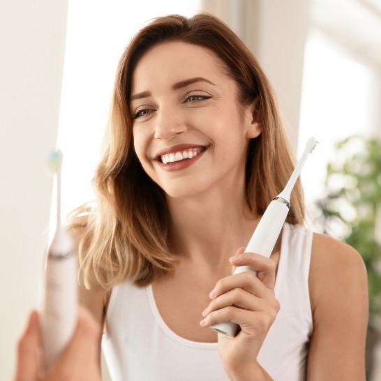 Woman brushing teeth to prevent dental emergencies