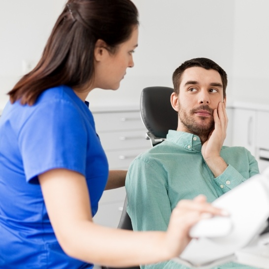 Man in dental office discussing the cost of treating dental emergencies