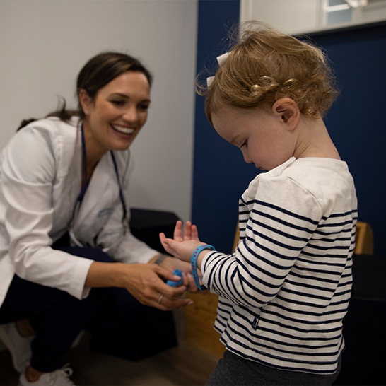 Dentist talking to child during dental checkup and teeth cleaning visit