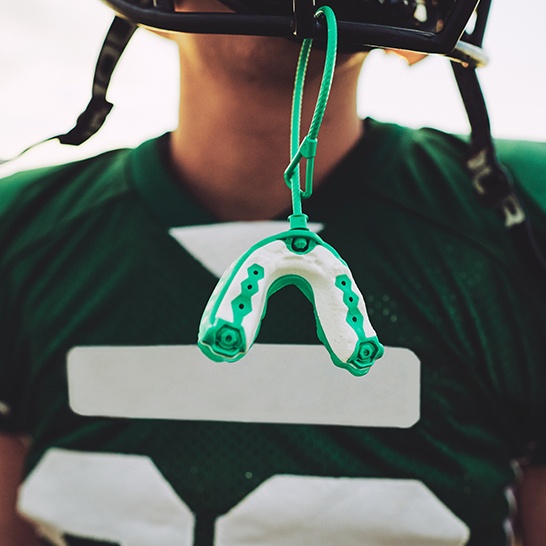 Athletic mouthguard hanging from helmet