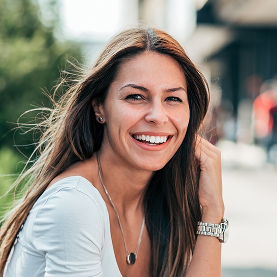 Woman sharing flawless smile after porcelain veneer treatment