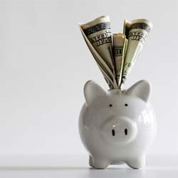 Piggy bank with money for cost of dental implants in Mission Viejo