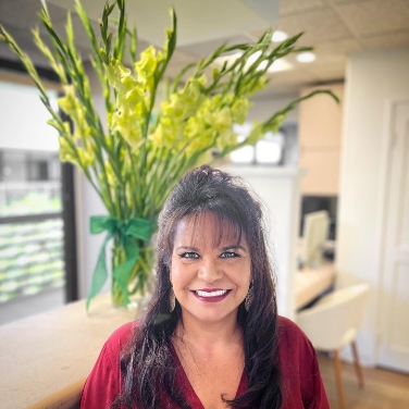 Dentist in Mission Viejo sitting on blue couch in dental office