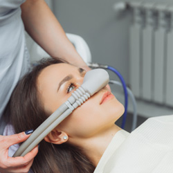 Closeup of patient putting nasal mask in place