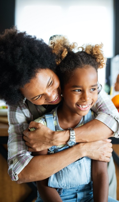 Mother giving daughter a hug after children's dentistry