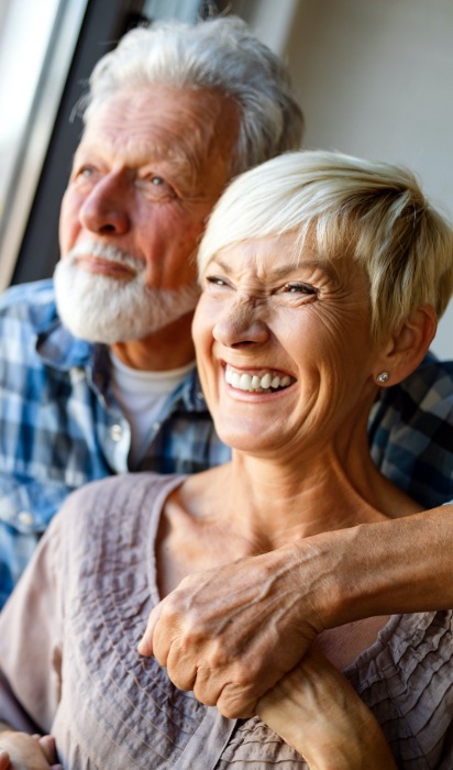 Man and woman smiling after periodontal therapy