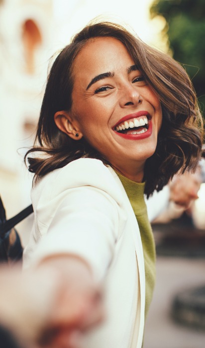 Woman with flawless smile after Invisalign treatment