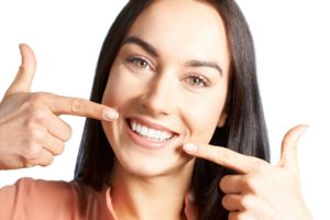 Woman pointing to white teeth