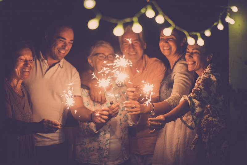 friends holding sparklers and smiling